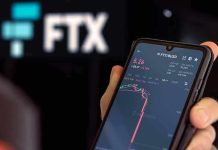 Hand holding phone with FTX trading app.