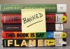 Stack of banned books with a sticky note.
