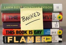 Stack of banned books with a sticky note.