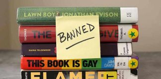Stack of banned books with a sticky note.