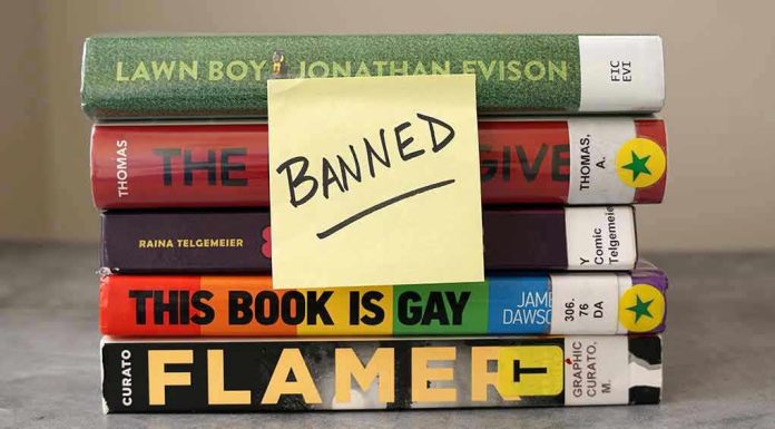 Stack of banned books with a sticky note.