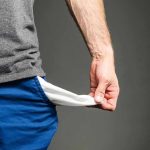 Person pulling out empty pocket from shorts.