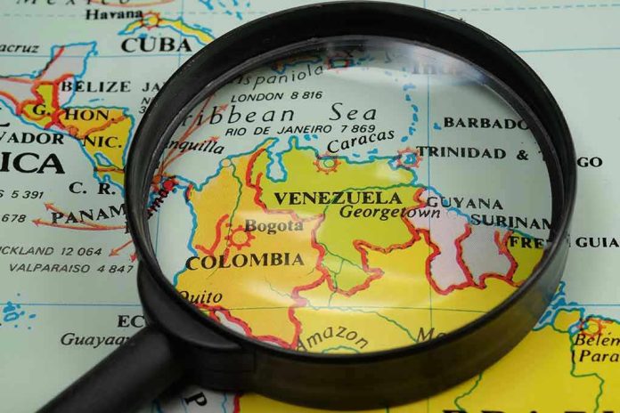 Magnifying glass focusing on Venezuela and Colombia on map.