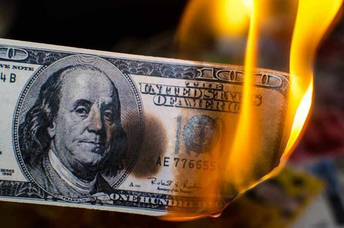 785880961 Burning hundred-dollar bill with visible flames.