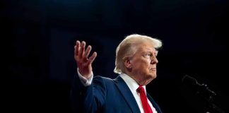 A man in a suit gesturing during a speech