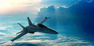 A fighter jet flying above the clouds during sunset