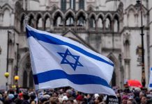 Israel Awards Its Highest Civilian Honor Israeli flag at a crowded outdoor event.