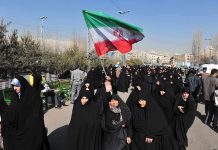 Iran Revolt ERUPTS Nationwide Group of women in black attire marching with an Iranian flag