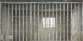 Empty rusty prison cell with a small window.