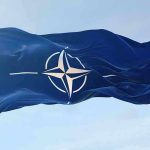 American Soldiers Dying — NATO Refuses to Fight NATO flag waving against blue sky.