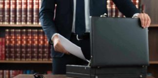 Gavel, lawyer, briefcase, and legal books on the table.