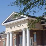 Fetterman Drops Bombshell: Socialist and Communist in Party? Exterior view of a city hall building with columns and a clear blue sky