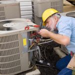 HVAC technician repairing an air conditioning unit outdoors