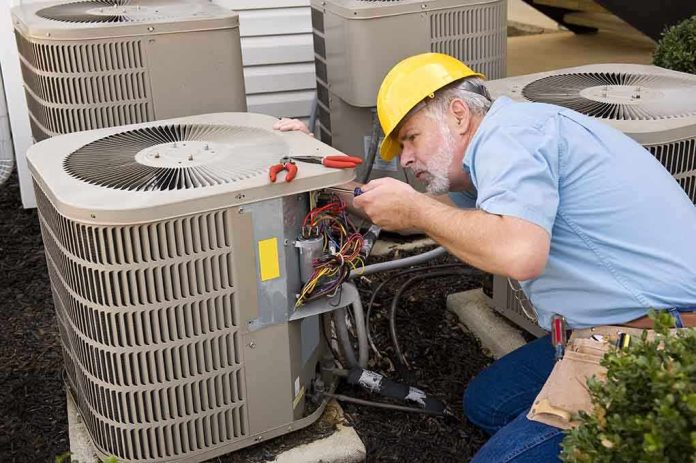 HVAC technician repairing an air conditioning unit outdoors