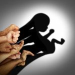 A collection of hands creating a shadow silhouette of a fetus