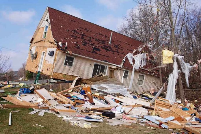 shutterstock_128948774 A severely damaged house tilted on its side surrounded by debris