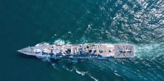 Aerial view of a naval ship navigating through the ocean