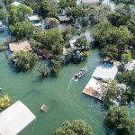 Aerial view of flooded neighborhood with rescue boat navigating streets