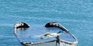 partially sunken boat in calm blue water