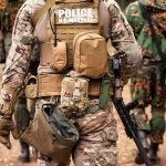 Tactical officers in camouflage gear walking on a forest trail