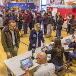 Crowd at check-in tables inside a gymnasium