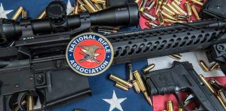 Rifles and pistol with ammunition on American flag