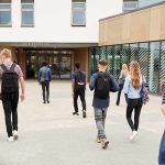 See What Minors Were Shown in THIS Classroom Students with backpacks walking toward a school entrance