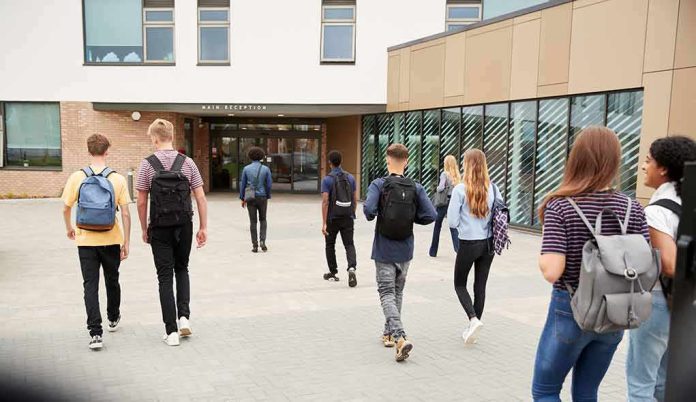 Students with backpacks walking toward a school entrance