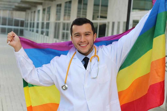 Smiling doctor holding a rainbow flag outdoors