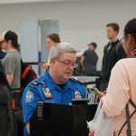 tsa officer checks a traveler's documents at airport security