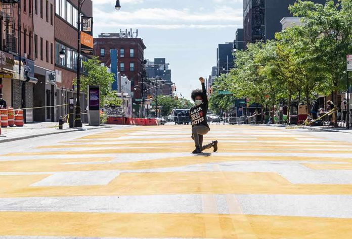 Person kneeling on painted city street raising fist