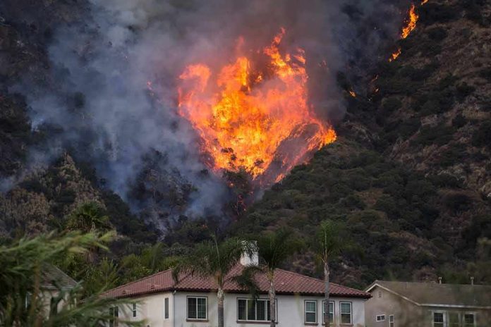 Wildfire burning on a hillside near homes