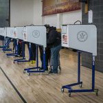 Voters at polling booths in a gymnasium