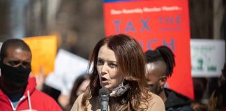 Woman speaking into a microphone at a rally