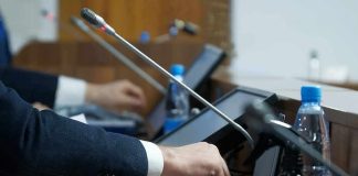 Person pressing a button on a conference microphone panel