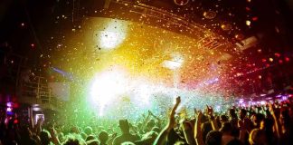 crowd at indoor concert with confetti and bright stage lights
