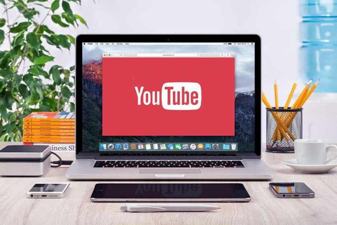 293731811 YouTube logo on a laptop screen on desk.