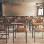 Empty classroom with rows of wooden desks and chairs