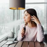 FDA Opens New Door for Vapes and Nicotine Pouches woman vaping by a window