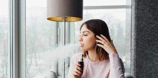 FDA Opens New Door for Vapes and Nicotine Pouches woman vaping by a window