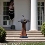 Podium with presidential seal in a garden colonnade