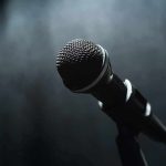 Microphone on a stand against a dark blurred background