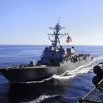naval destroyer sailing at sea with flag flying
