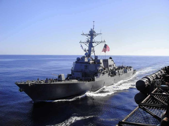 naval destroyer sailing at sea with flag flying