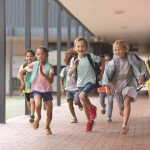 Group of schoolchildren running down a hallway