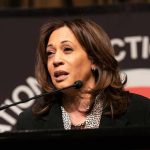 Kamala Harris speaking at a podium with a microphone