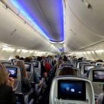 Duct-Taped Midair Chaos Triggers Costly Fallout Airplane cabin with passengers seated and seatback screens