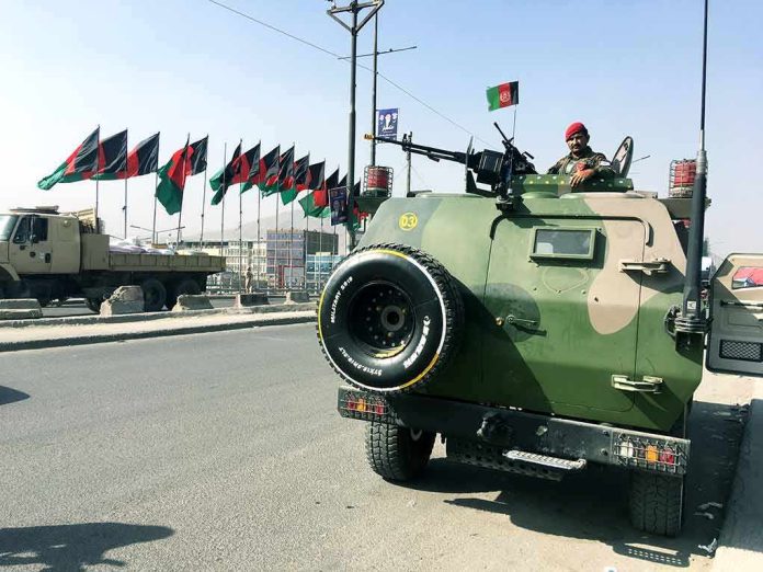 Armored military vehicle with soldier and mounted gun on city street