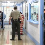 MS-13 ‘Executioner’ Freed — Here’s Why Corrections officers escort an inmate in a jail hallway