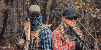 Mexican Cartels Say They Are NOT Scared of Trump Two armed individuals in tactical gear standing back to back in a forest